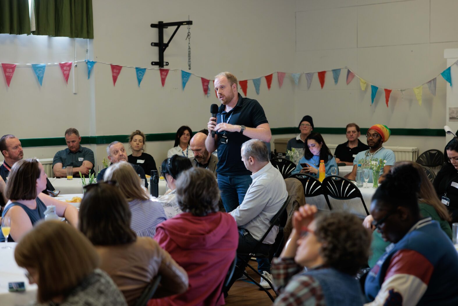 Picture of a man holding a microphone sharing a story with an audience