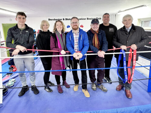 Image of people standing in a boxing ring posing for a picture during a visit to Launch Pad