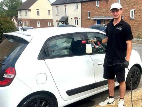 Picture shows grant recipient Kieran Jackson standing by a car he is cleaning